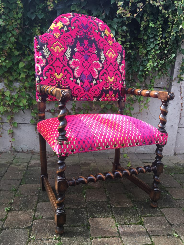 Geherstoffeerde antieke stoel in felroze kleuren